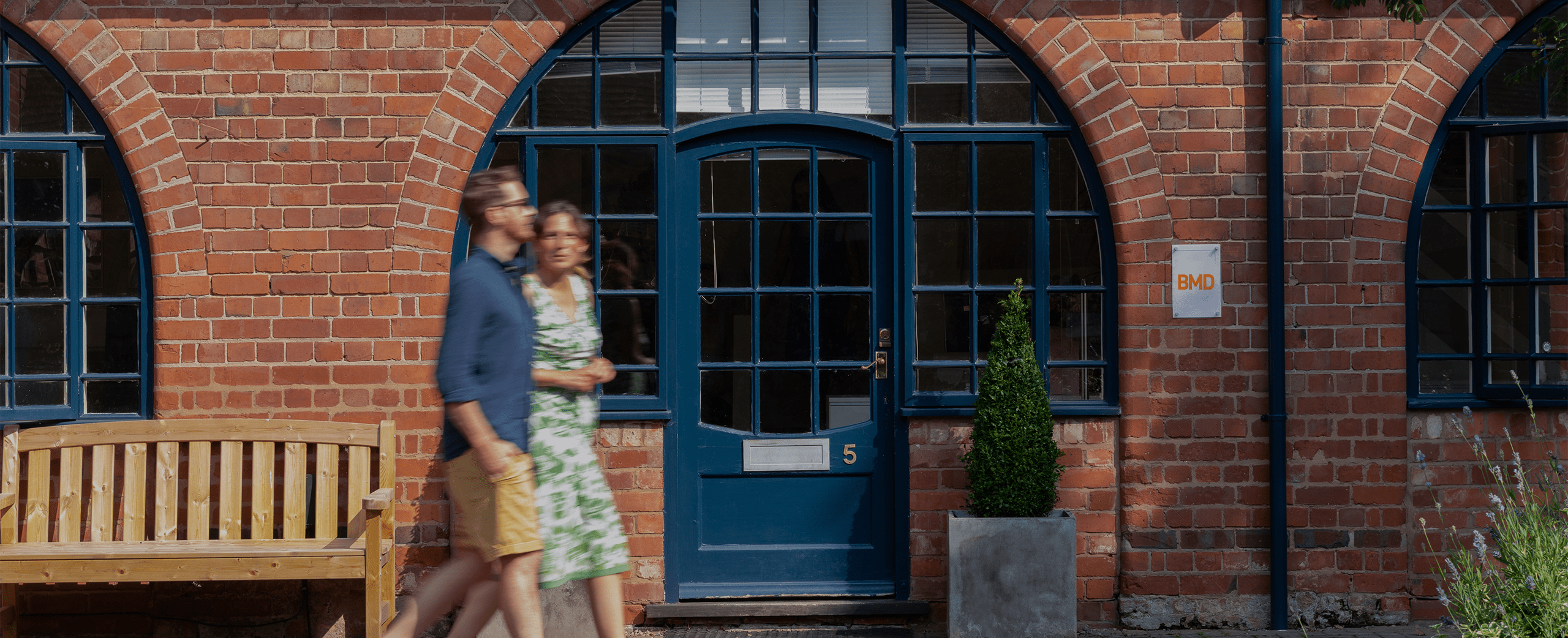 A photograph of two BMD employees walking through a courtyard