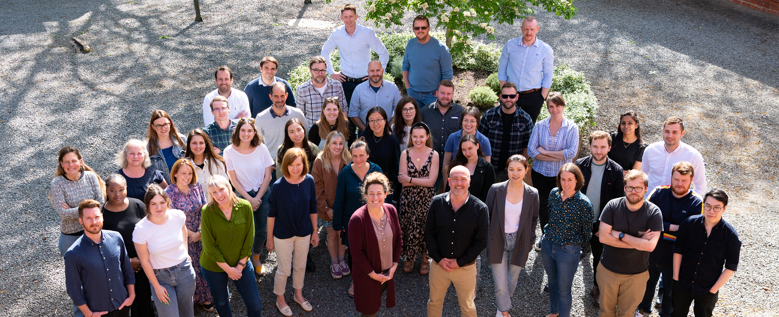 A group photograph of BMD employees standing in a courtyard