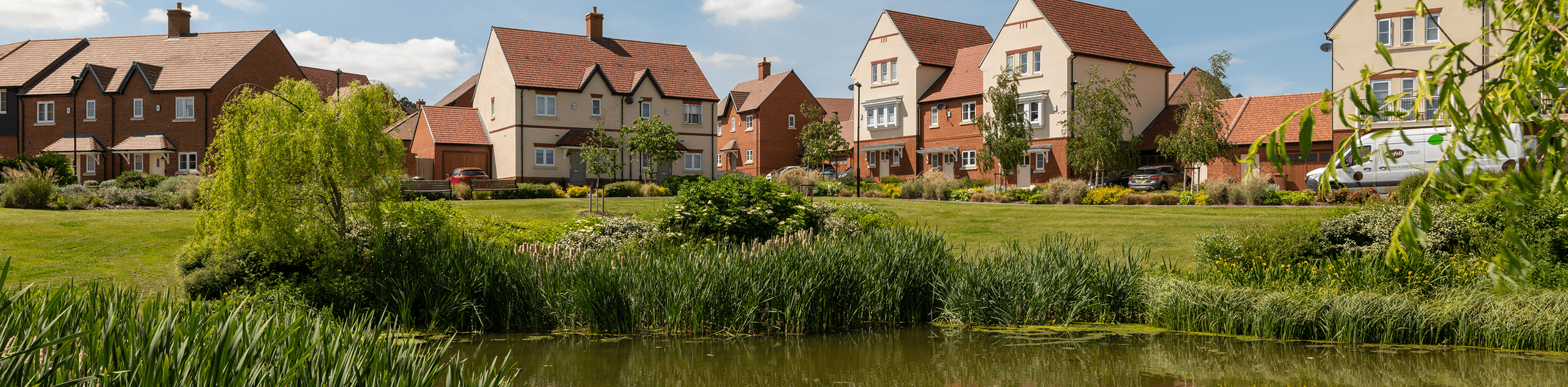 A photograph of the wildlife pond, overlooked by housing at Woodhurst Park. © BMD