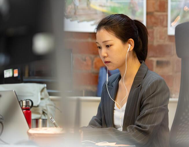 A photograph of a BMD employee working at a desk in the office