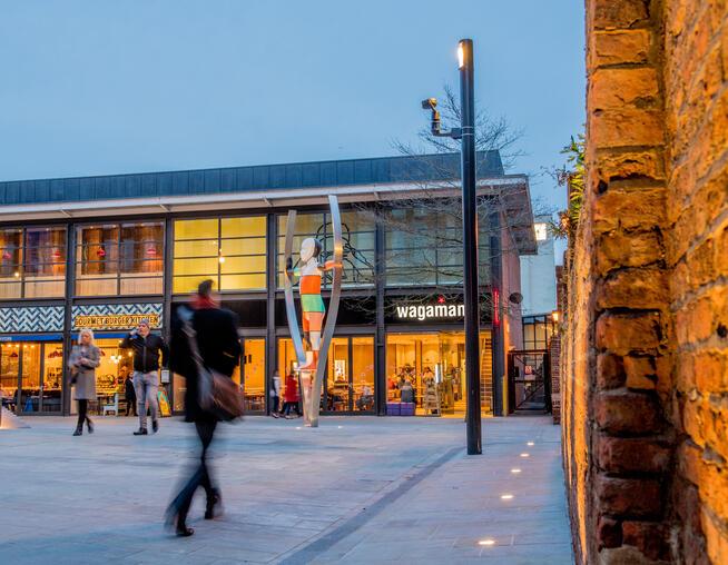 A photograph of restaurant frontages, public art and bespoke lighting features at The Exchange. © BMD 