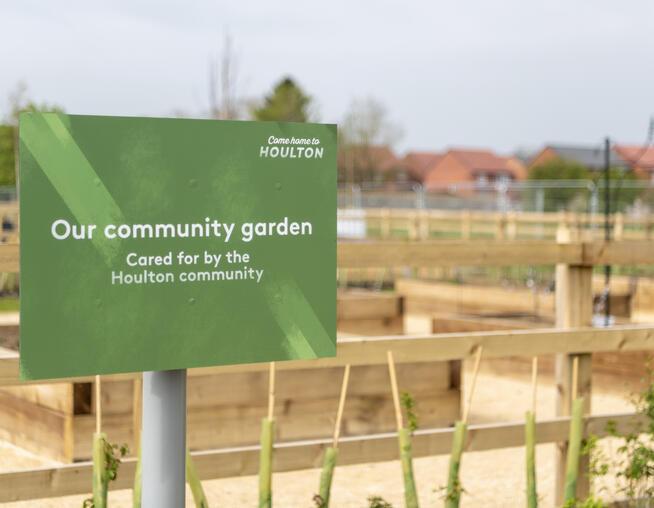 A photograph of welcome sign at the Community Gardens, Houlton, reading "Our community garden. Cared for by the Houlton Community". © BMD